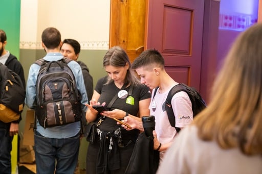 Two attendees looking at their smartphone