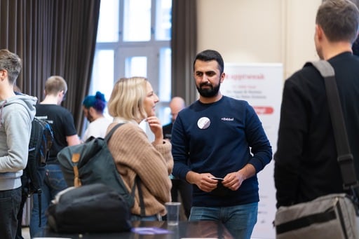 A man and a woman having a discussion in the audience.