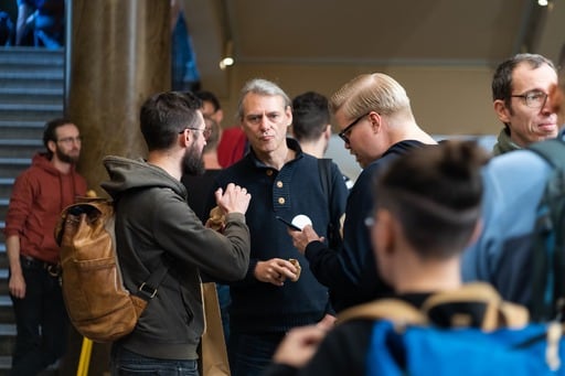 Three men having a discussion in the foyer