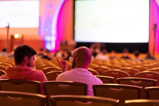 Photo of two men having a discussion in a nearly empty congress hall