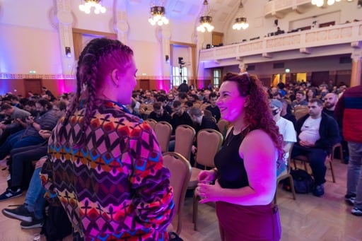 Yarden having a discussion with another woman at the front of the congress hall